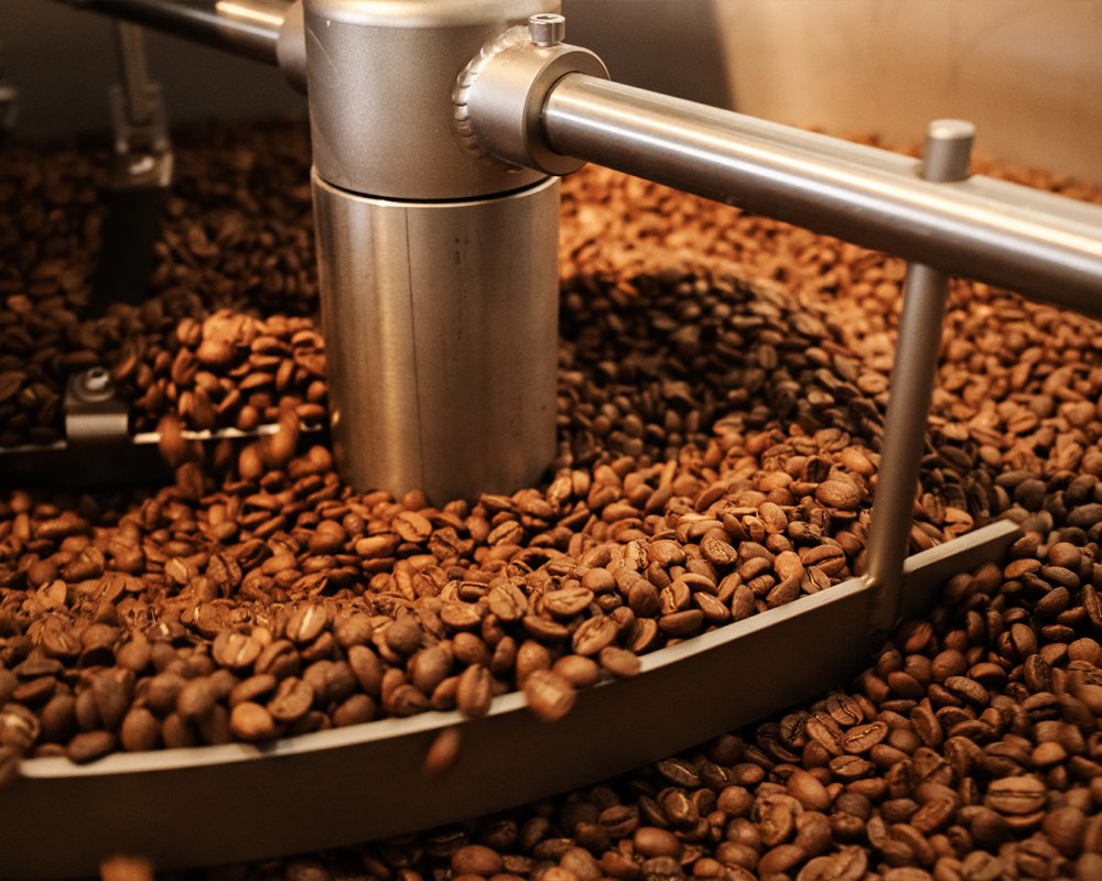 Čerstvě pražená zrnková káva Kopi Bean v bubnu pražičky